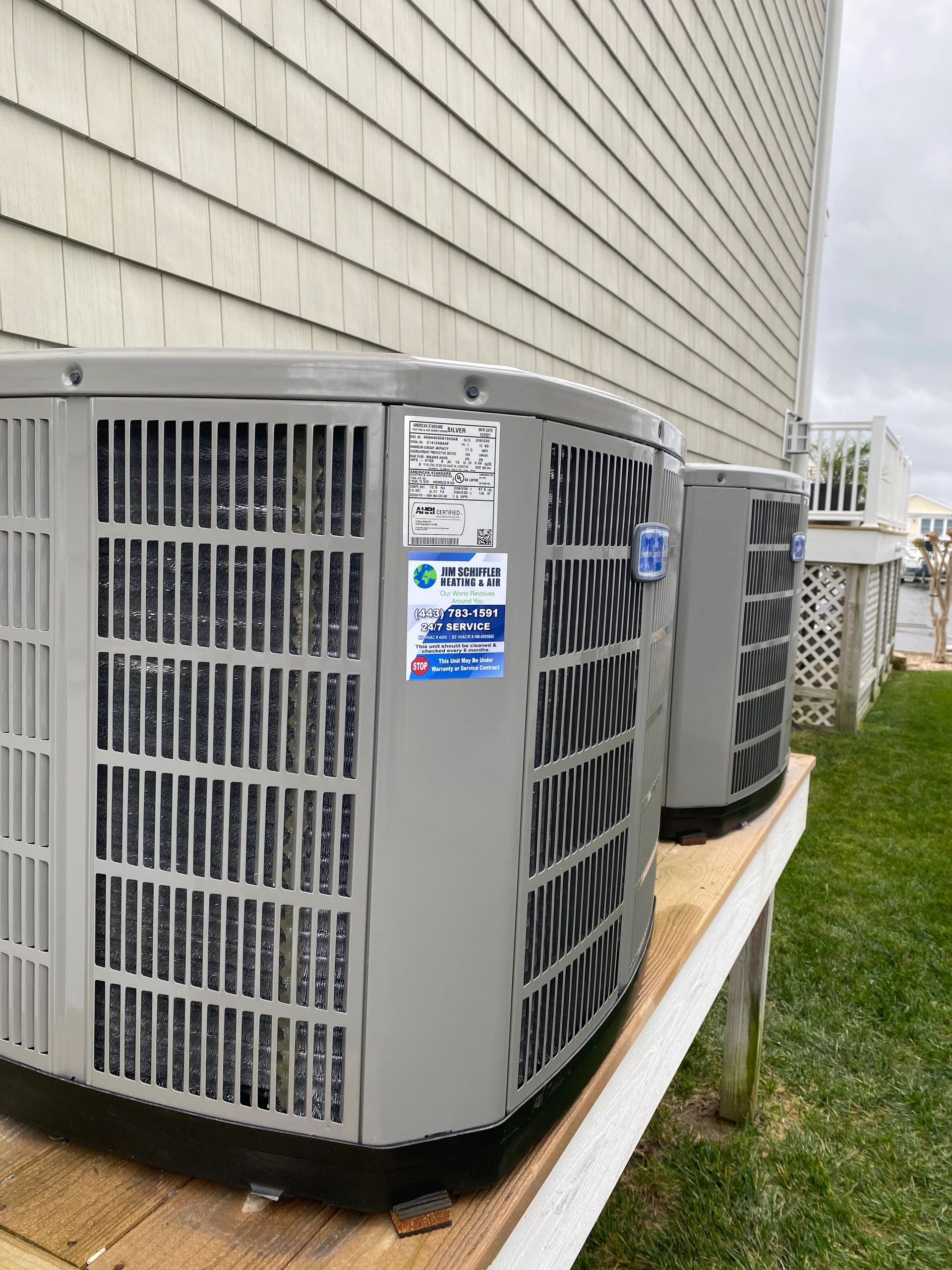 Twin American Standard outdoor units installed on a raised coastal platform