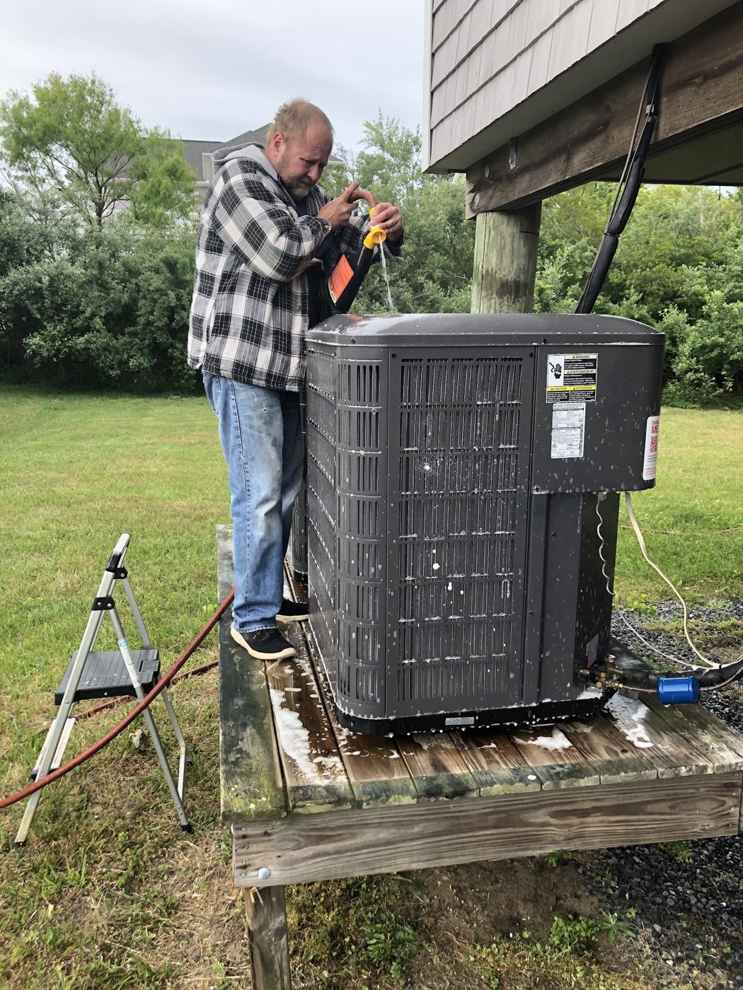 Jim Schiffler crew member servicing an outdoor system on a raised stand