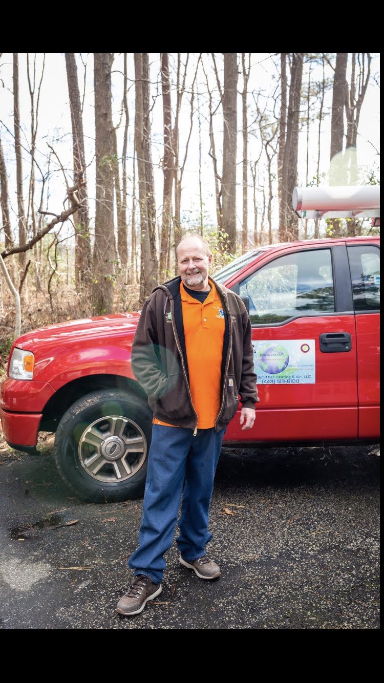 Jim Schiffler standing beside his red Jim Schiffler Heating & Air service truck
