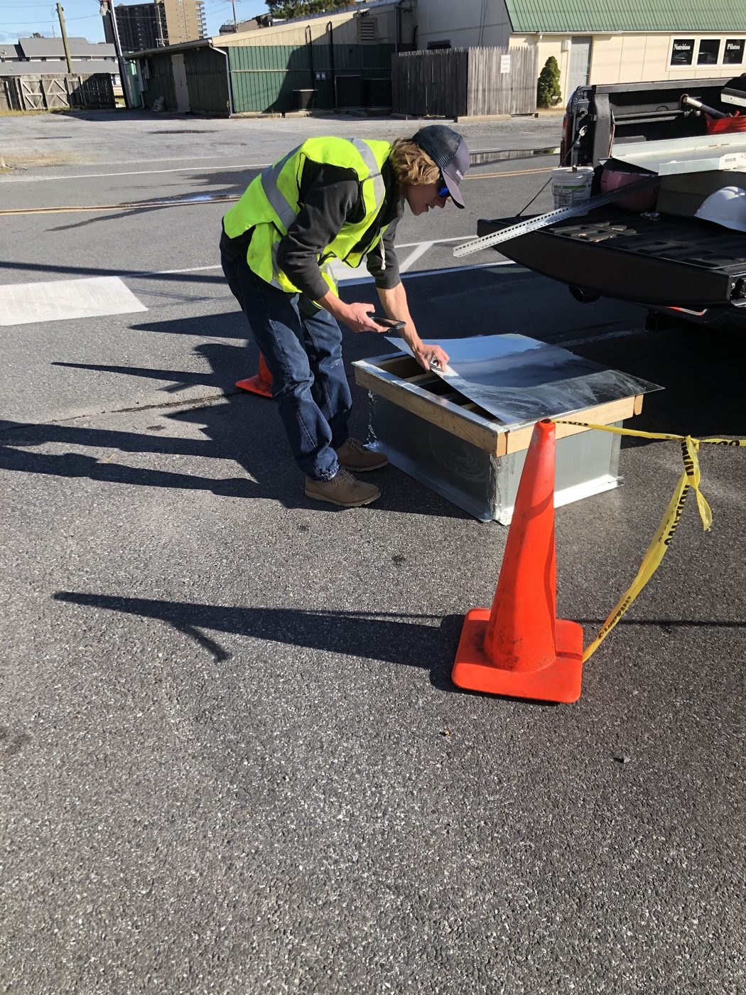 Crew member fabricating ductwork on a truck tailgate