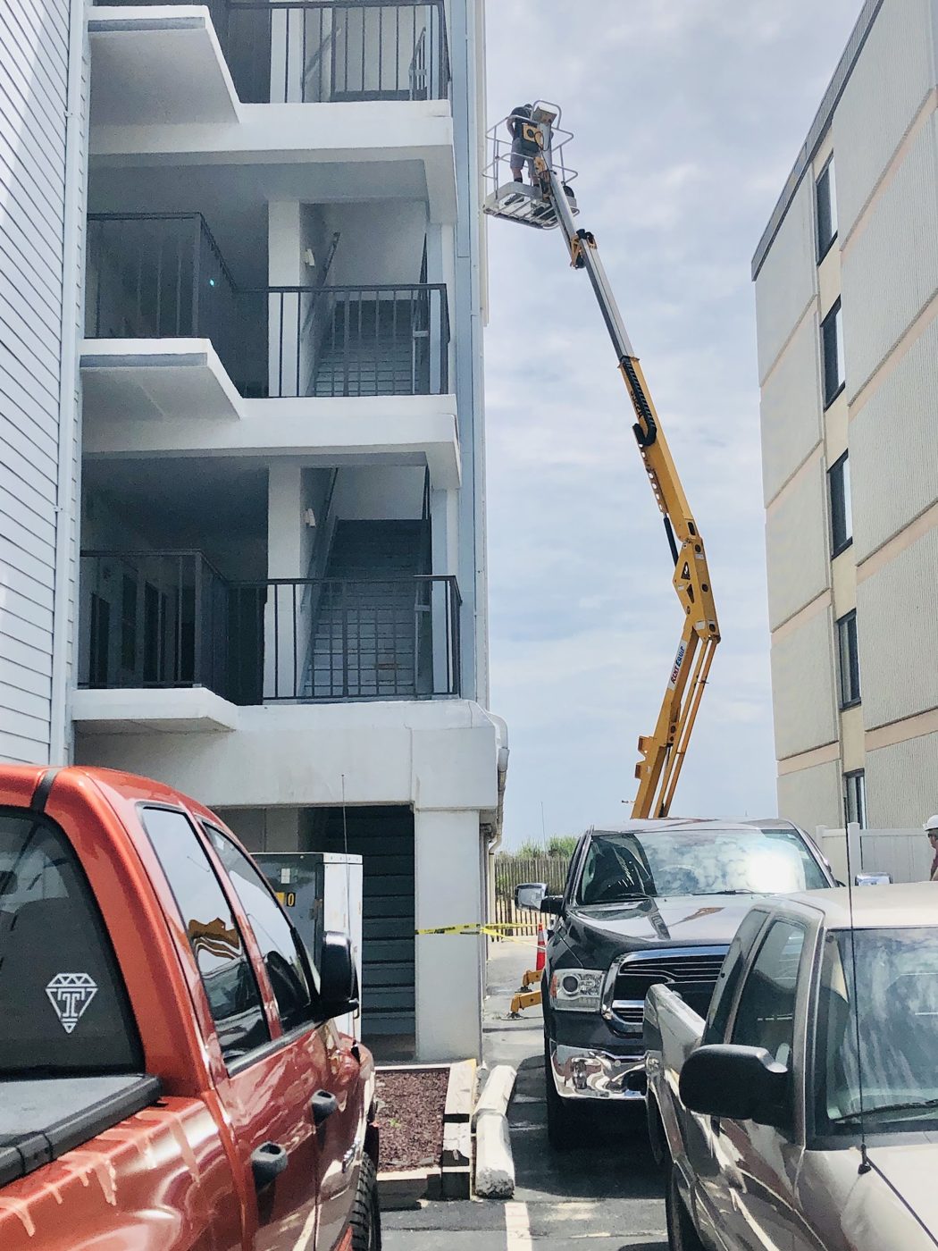 Boom lift raising equipment to an upper floor of a condo building