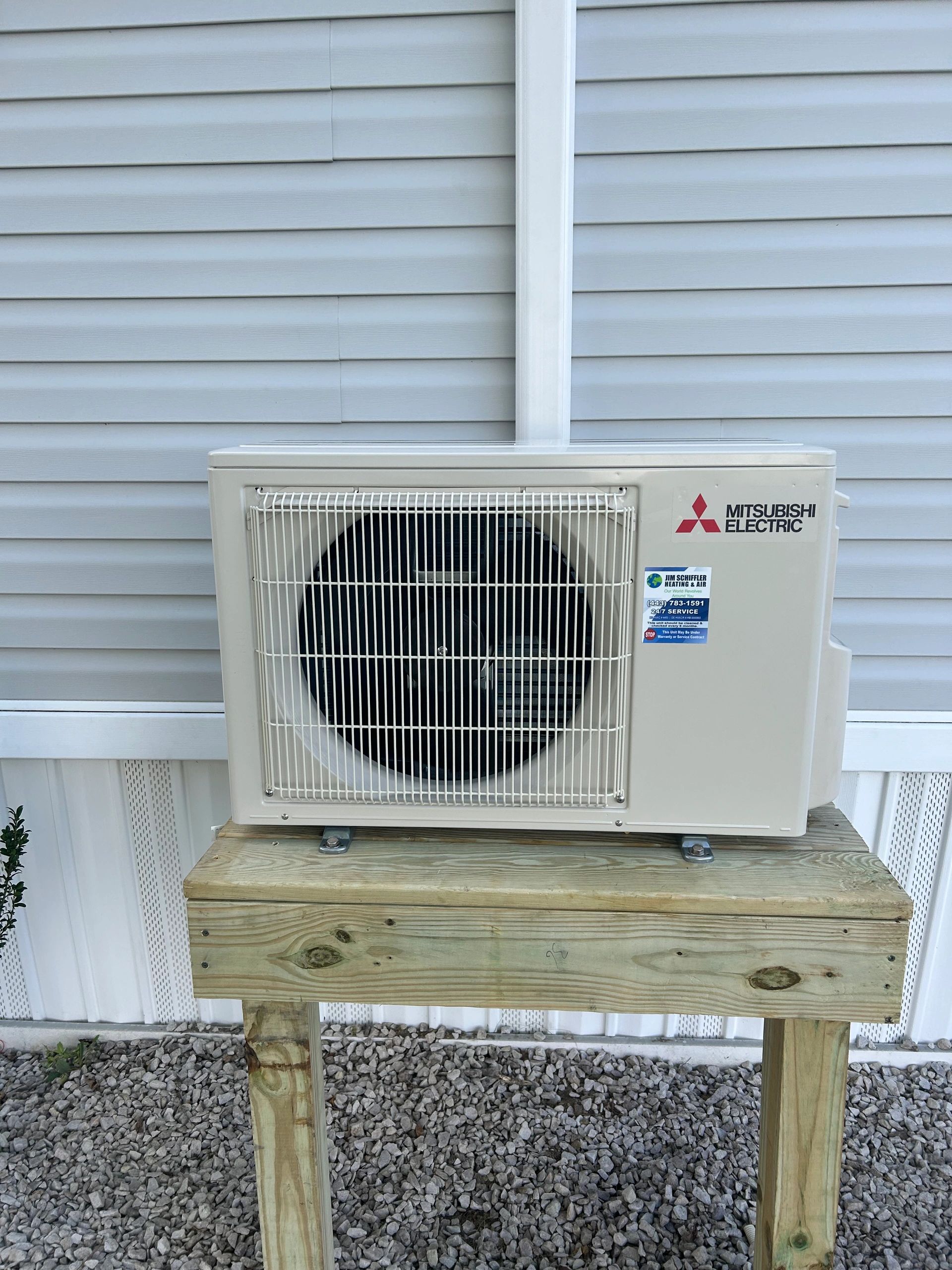 New Mitsubishi Electric ductless mini-split outdoor unit mounted on a treated wood stand