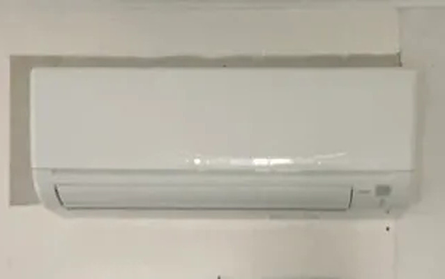 White wall-mounted ductless mini-split indoor unit installed in a coastal home